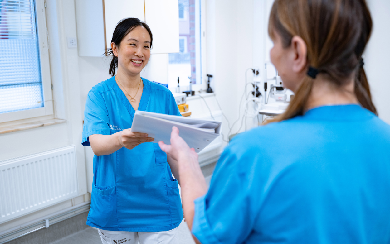 Vårdpersonal lämnar dokument till kollega